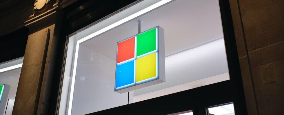 © Turag Photography - Unsplash, Microsoft-Logo auf Glasfenster in Gebäude, im Dunkeln leuchtend