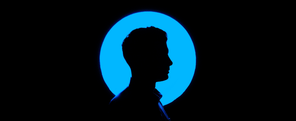 Person (Silhouette) dunkel vor blauem Kreis im Hintergrund