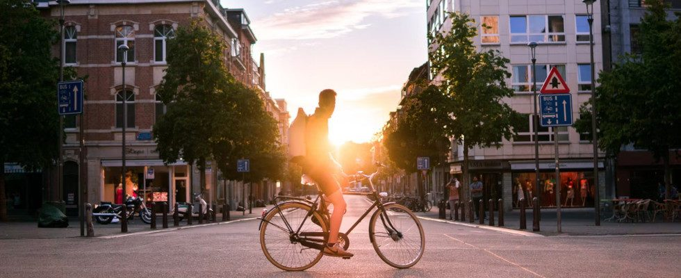 Mann auf einem Fahrrad in der Innenstadt bei Sonnenuntergang