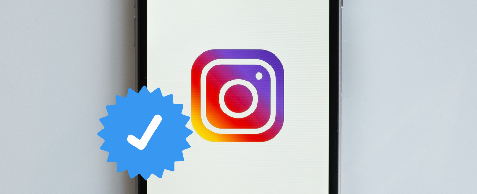© Kenny Eliason - Unsplash via Canva, Instagram-Logo auf Smartphone, Verifizierungshaken, weiß auf blau