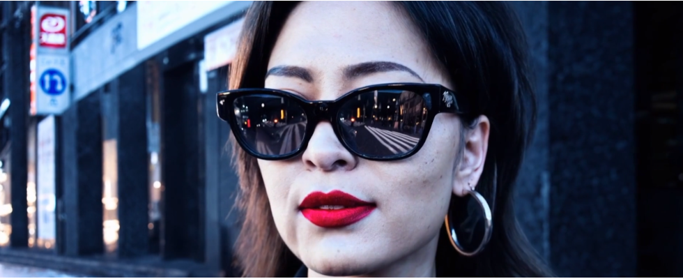 © OpenAI, Sora AI Video Frau mit Sonnenbrille, Gesichtsdetails sichtbar, roter Lippenstift