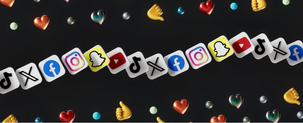 © Igor Omilaev - Unsplash Social-Media-Logos in einer Reihe, Emojis und schwarzer Hintergrund