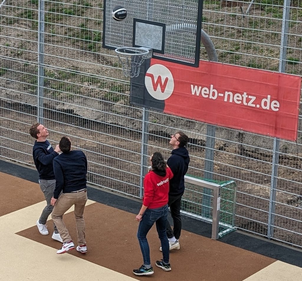 Mitarbeitende von webnetz spielen Basketball.
