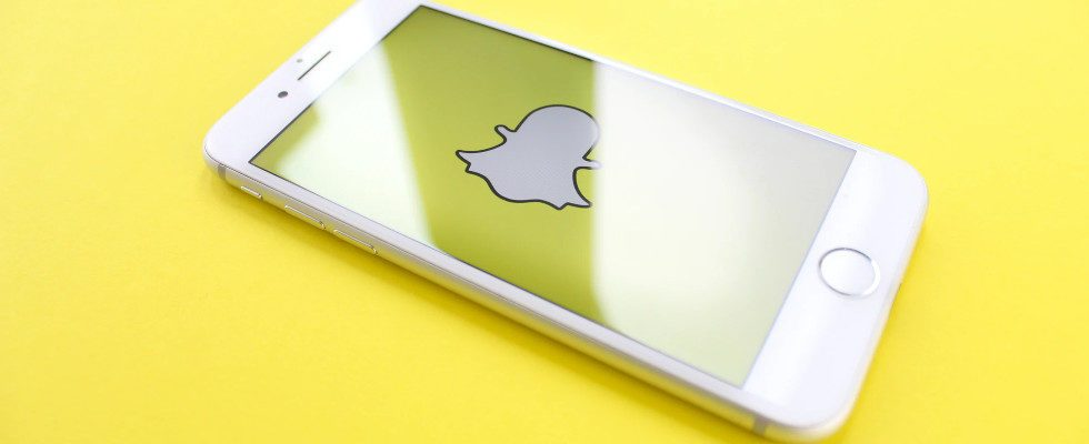 Snapchat Logo auf Display auf gelbem Untergrund