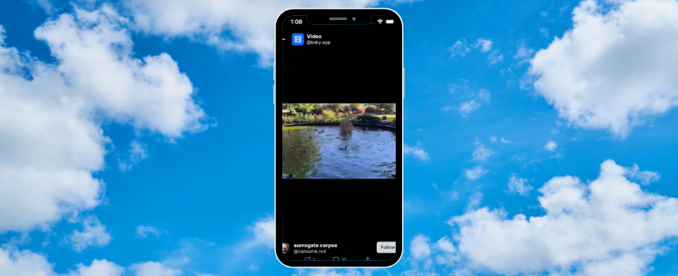 Wolken vor blauem Himmel, mittig ein Smartphone mit Bluesky-Video-Feed auf Screen