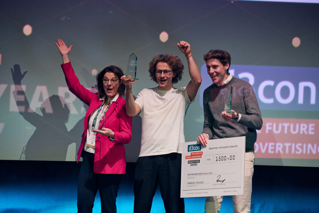 Glückliche Gesichter beim Innovation Award 2026, © d3con, drei Personen auf Bühne mit Preis