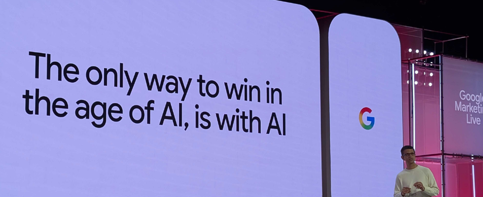 Shashidhar Thakur auf der Google Marketing Live-Bühne, Schriftzug zu AI auf Screen