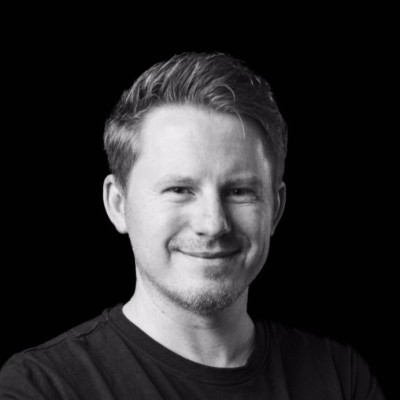 Schwarz-Weiß-Porträt von Dimitri Herber, Geschäftsführer Marketing bei Weischer.Cinema, mit kurzen Haaren und dunklem T-Shirt vor schwarzem Hintergrund.